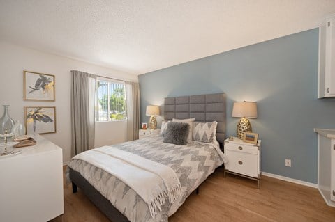 a bedroom with a bed and a dresser and a window