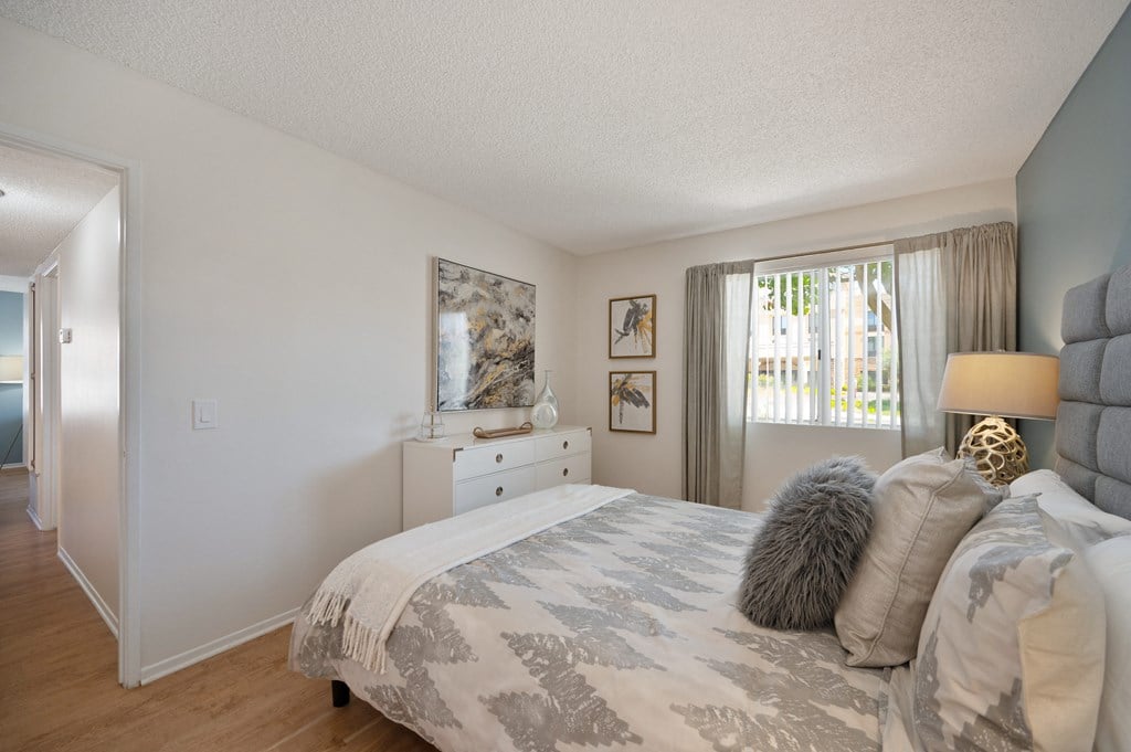 a bedroom with a bed and a dresser and a window