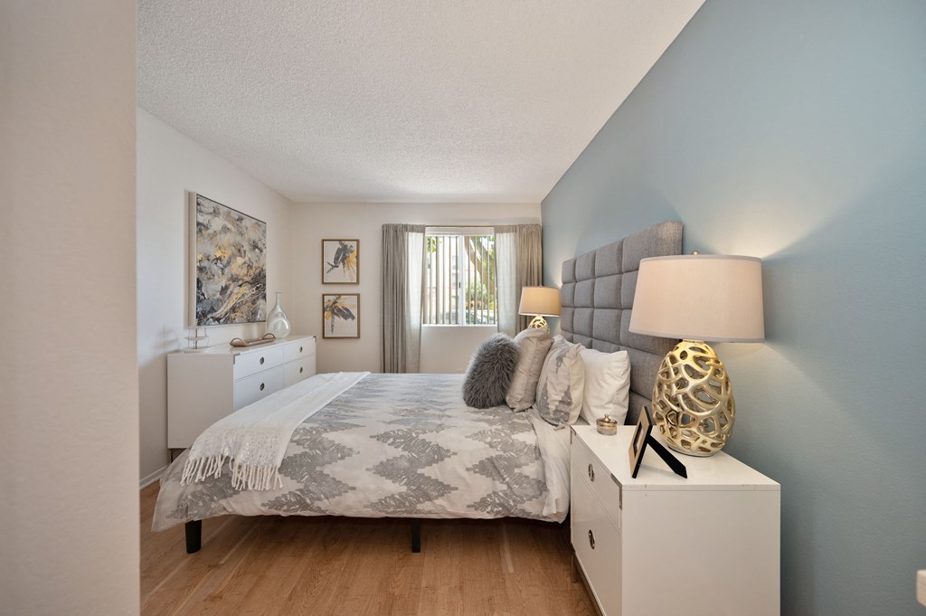 a bedroom with a bed and a dresser and a window