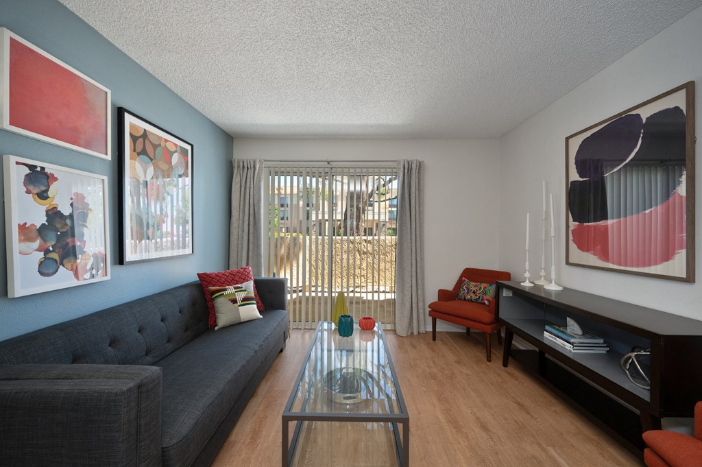 a living room with a gray couch and a glass coffee table