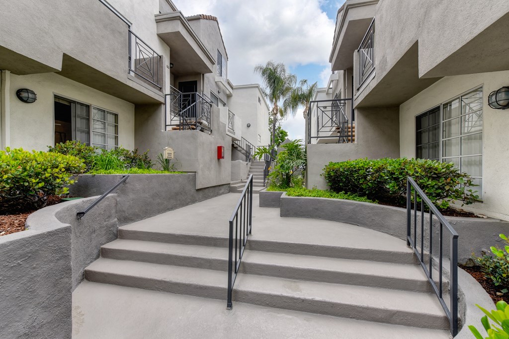 Long staircase area with only 3 steps leading to apartment entrances. 