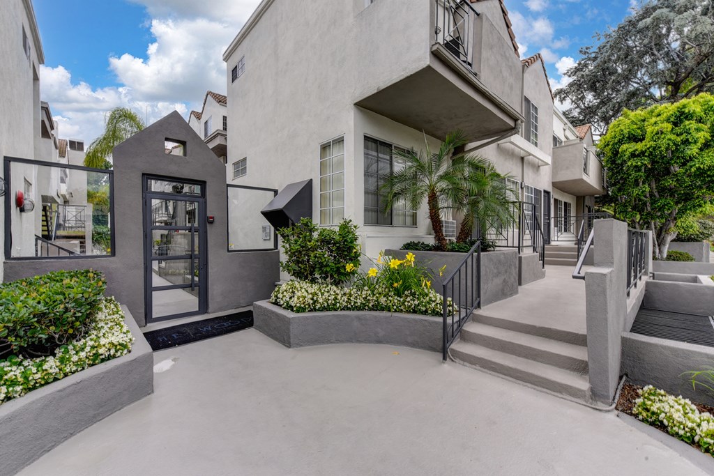 Apartment completx grounds. There are numerous planters filled with shrubs and flowers. 