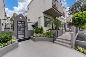 Apartment completx grounds. There are numerous planters filled with shrubs and flowers. - Photo Gallery