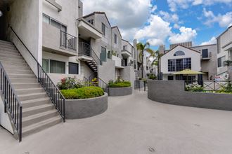 Community grounds and walk path throughout the community. There are staircases that lead up to the 2nd floor homes and the swimming pool area is in the distance. - Photo Gallery
