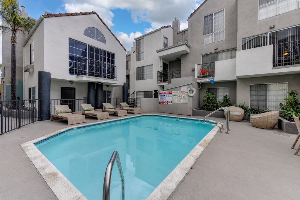 Community Swimming pool located in the middle of the apartment community with apartment buildings overlooking the pool deck.