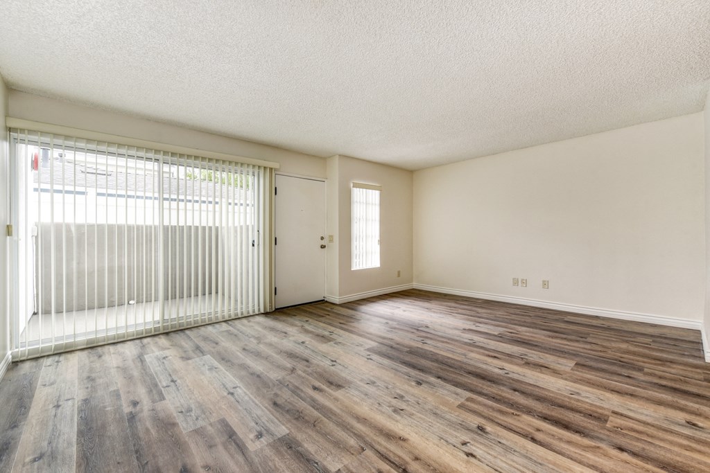 Vacant apartment home located on the first floor with hardwood inspired flooring through out with views of the sliding glass door to the private patio & the front door. 