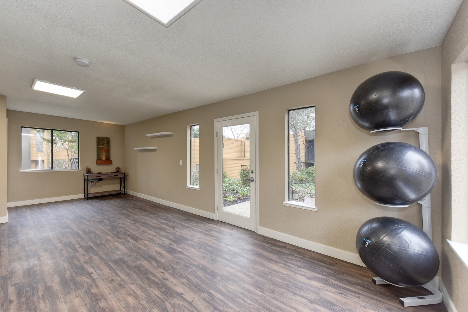 Community Yoga Studio with Hardwood Inspired Floor, Yoga Balls, Large Window and Wicker Basket with Yoga Mats at Fountains of Fair Oaks, Fair Oaks, 95628