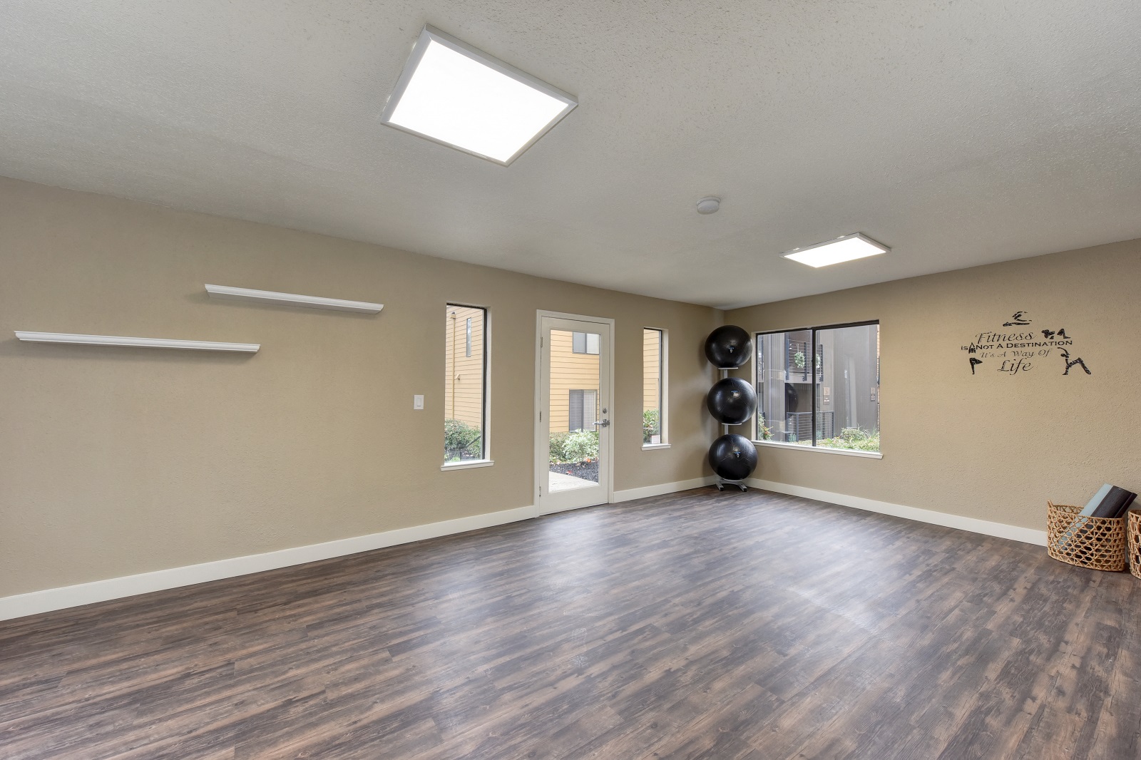 Community Yoga Studio with Hardwood Inspired Floor, Yoga Balls, Large Window and Wicker Basket with Yoga Mats at Fountains of Fair Oaks, Fair Oaks, CA 95628