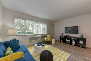 Living Room with Hardwood Inspired Floors Living Room with Hardwood Inspired Floors, Yellow/White Rug, Large Window with Blinds, Blue Sofa and Flat Screen Television - Photo Gallery 4