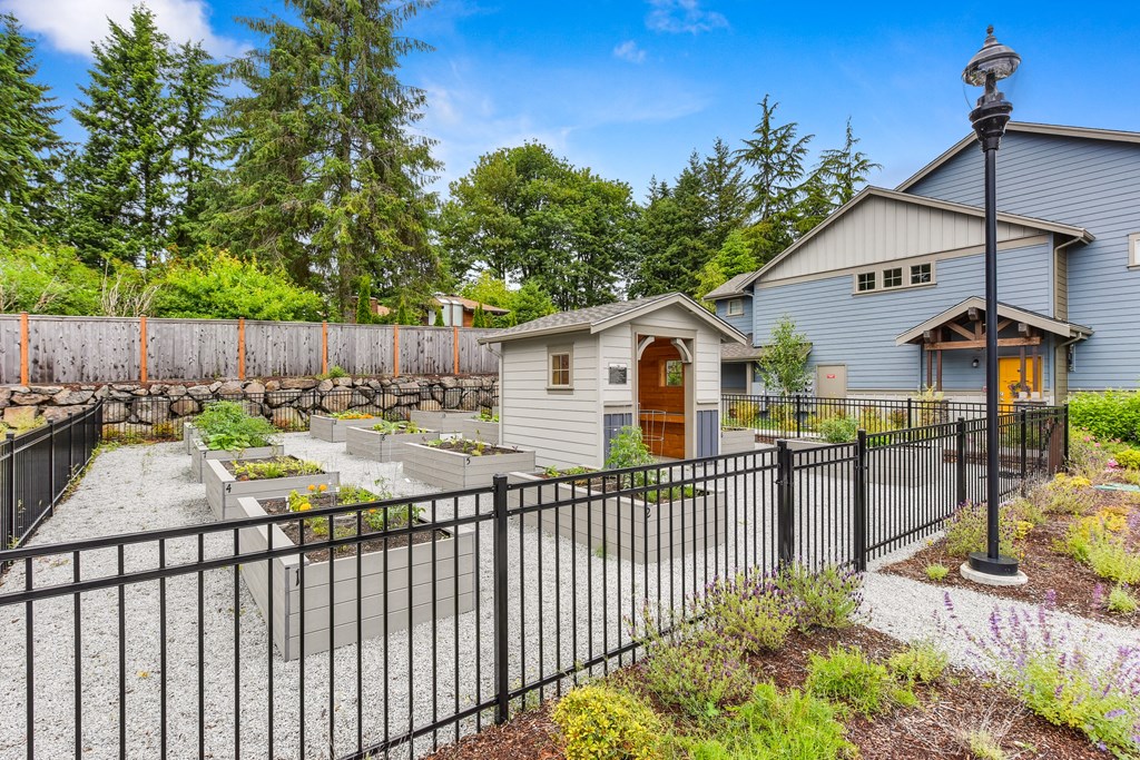Gated community garden with raised planter boxes or growing items on-site. 