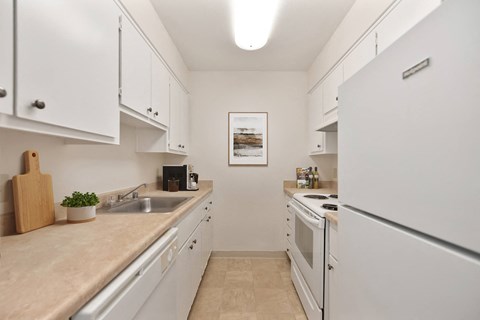 a kitchen with white cabinets and a sink and a refrigerator