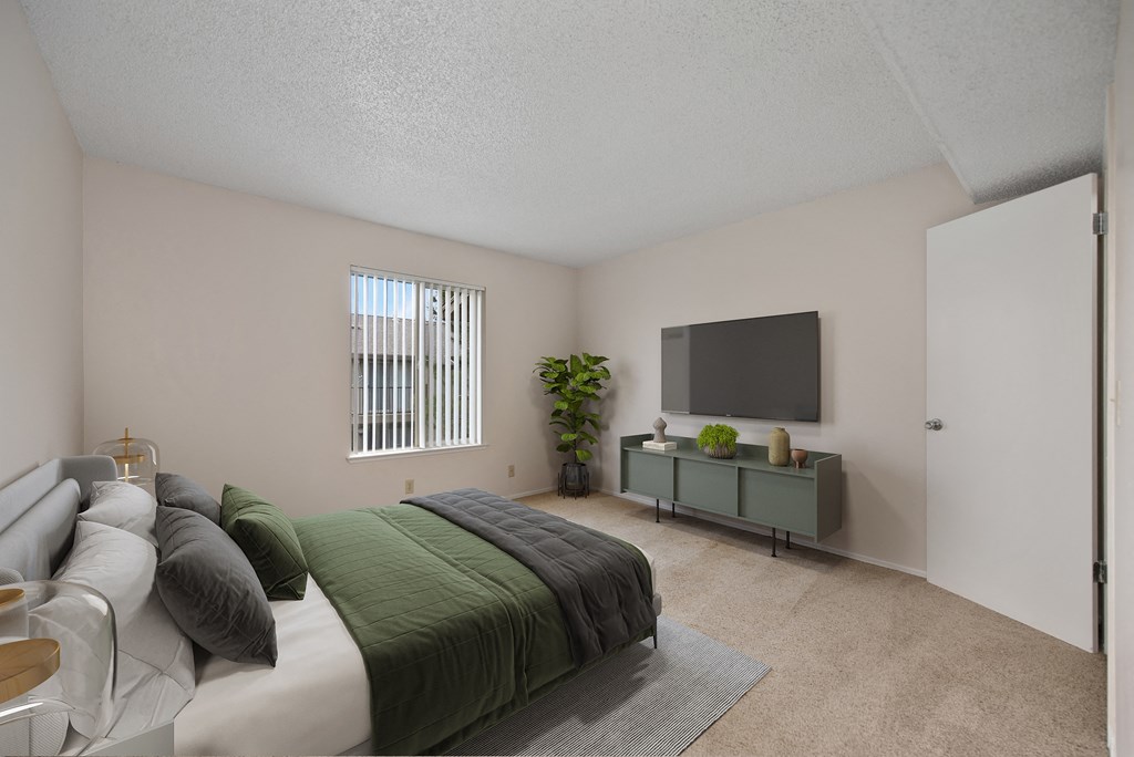a bedroom with a large bed and a tv on the wall