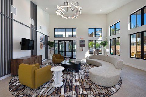 A modern living room with a patterned rug and a chandelier.