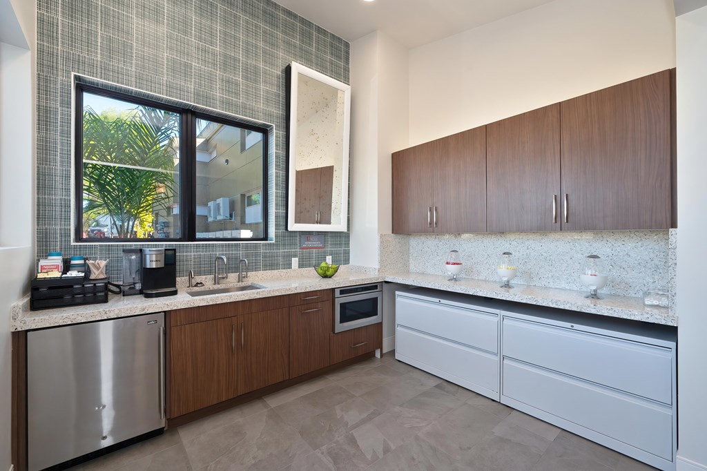 A kitchen with a stainless steel dishwasher and wooden cabinets.