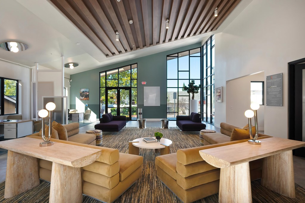 A modern living room with a large window and a wooden ceiling.