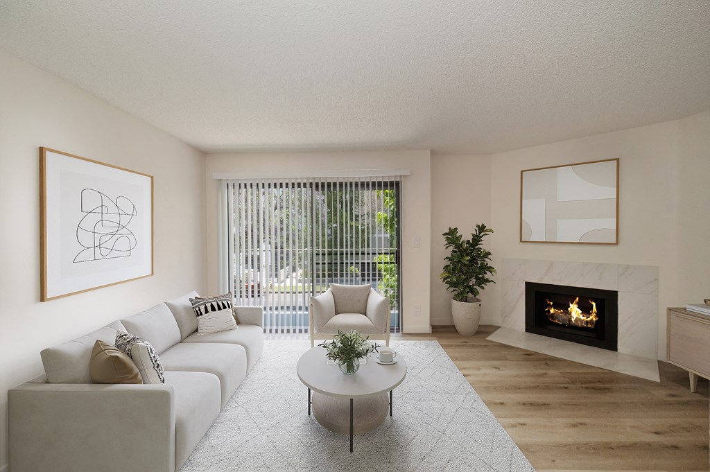 a living room with a white couch and coffee table in front of a fireplace at Croft Plaza Apartments, West Hollywood