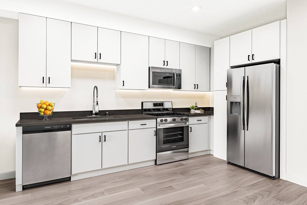 a white kitchen with stainless steel appliances and white cabinets at Canyon Terrace Apartments, California, 95630