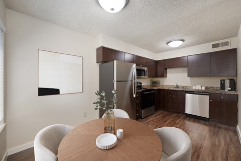 a kitchen and dining room with stainless steel appliances and a wooden table
