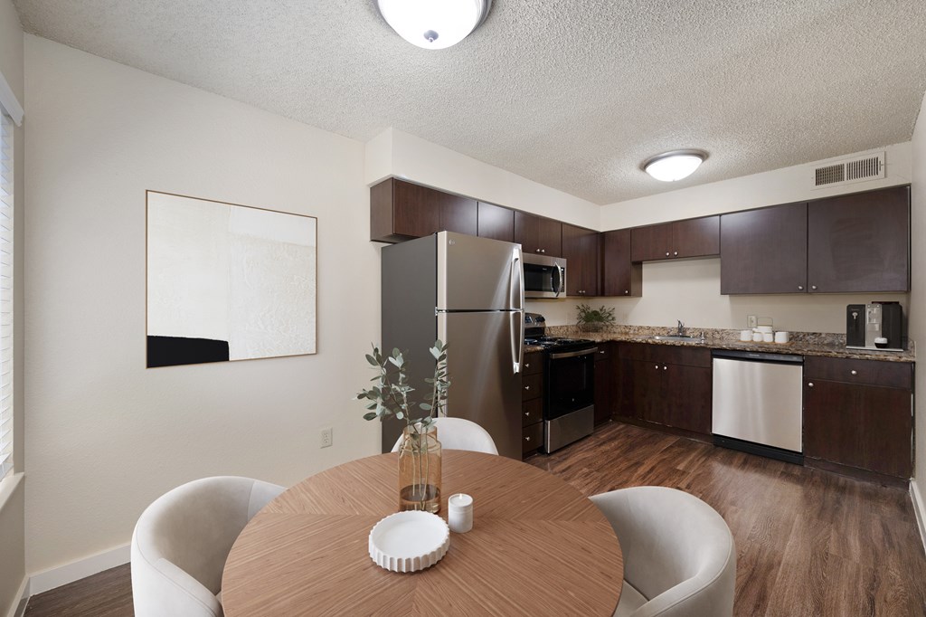 a kitchen and dining room with stainless steel appliances and a wooden table at Fountains of Fair Oaks, California