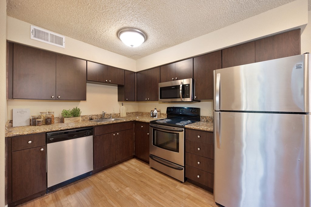 full kitchen with stainless steel appliances and wood flooring at Fountains of Fair Oaks, California
