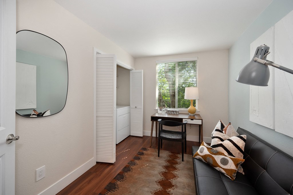 Den style room with a black couch and a desk with a mirror and a window at Folsom Ranch, Folsom, California