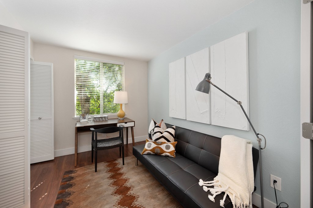 Den with a black couch and a desk with a lamp at Folsom Ranch, Folsom, CA