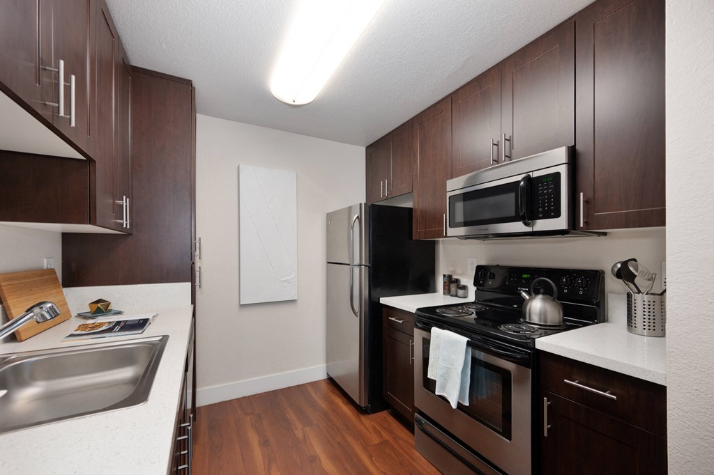 full kitchen with stainless steel appliances and dark wood cabinets at Folsom Ranch, California, 95630