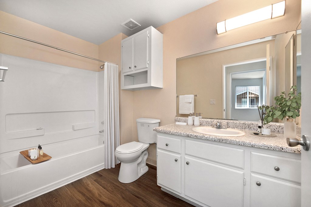 a bathroom with white cabinets and a toilet and a sink