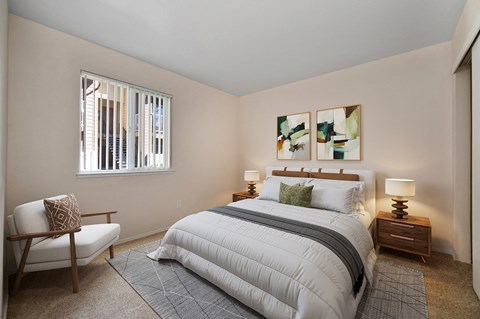 a bedroom with a bed and a chair and a window
