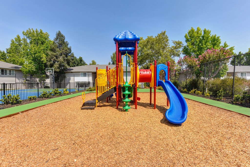 Outdoor Play Structure On-site with bark around it. at The Renaissance Apartments, Citrus Heights, CA