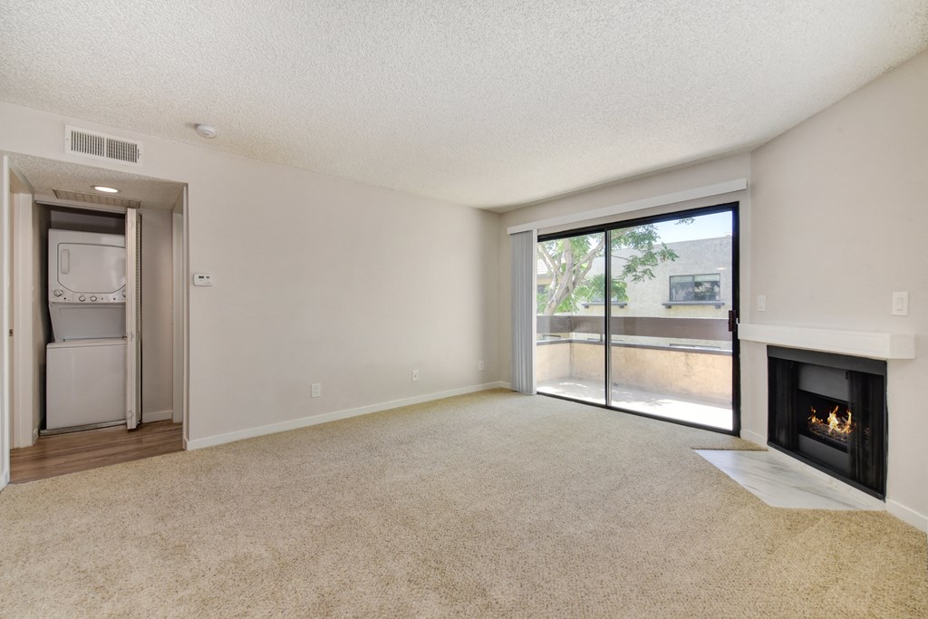 an empty living room with a fireplace and a sliding glass door