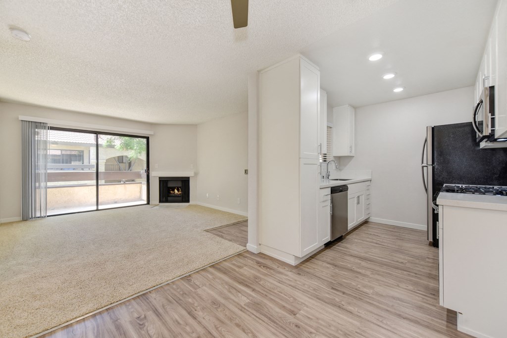 an open living room and kitchen with a sliding glass door to a patio