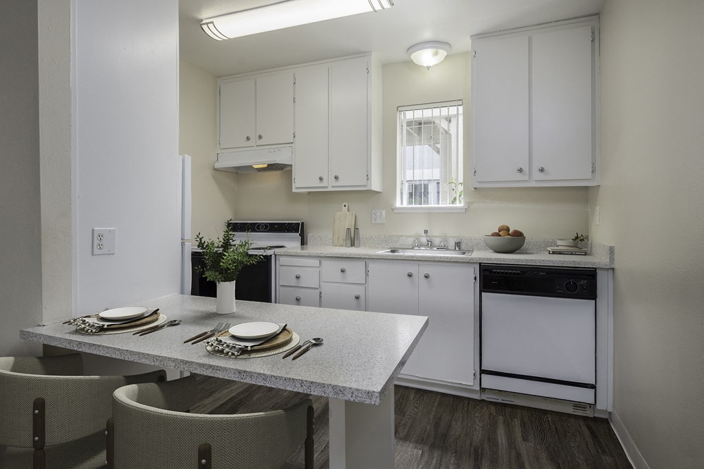 a kitchen with white cabinets and a table and chairs