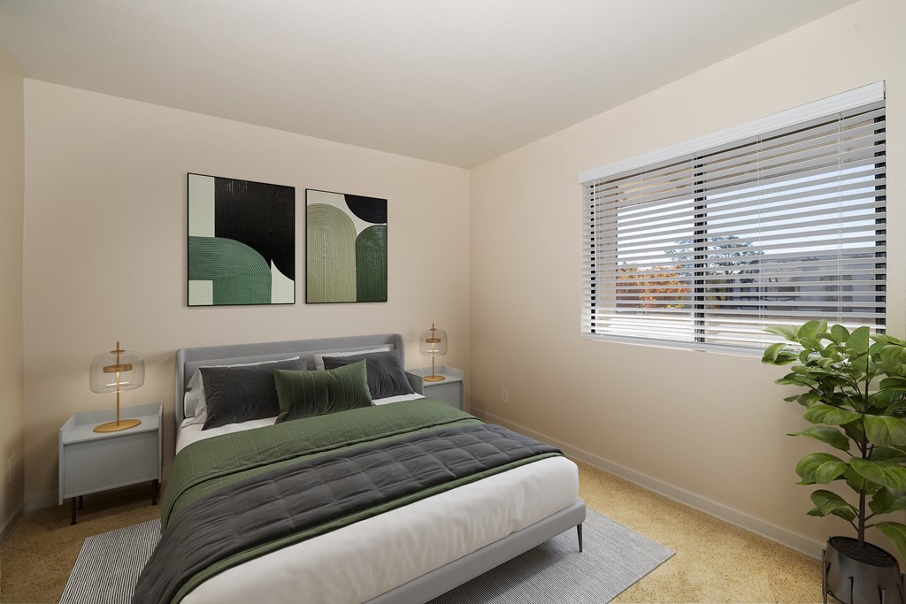 A bedroom with a large bed and a painting on the wall.