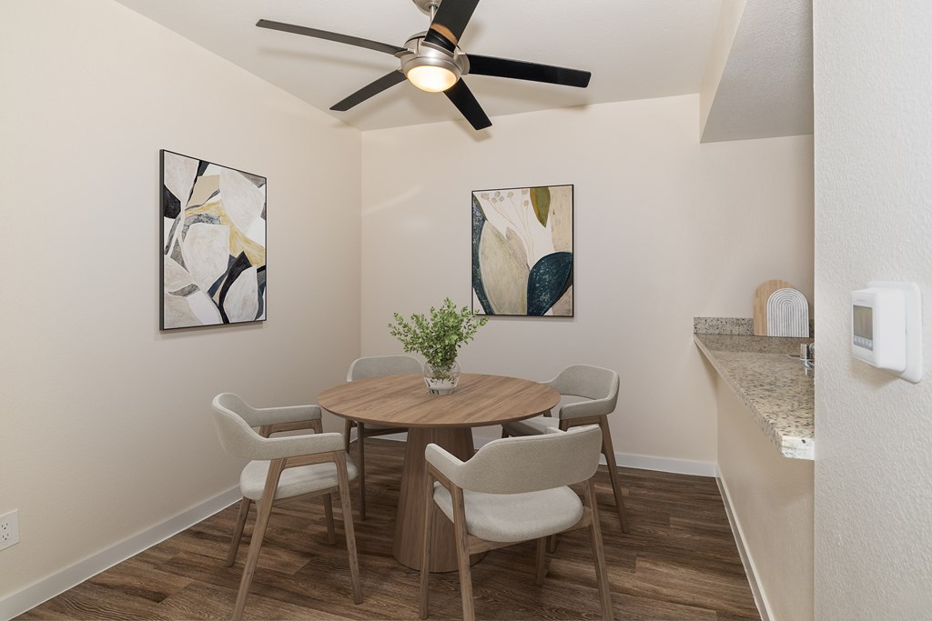 A dining room with a table and chairs.