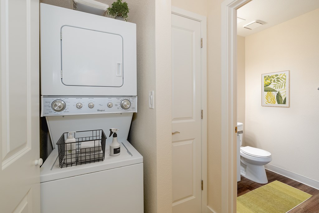 A white washing machine is in a small laundry room.