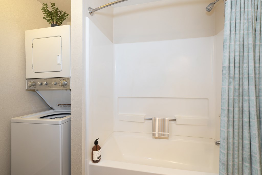 A white bathroom with a white tub and a white oven.