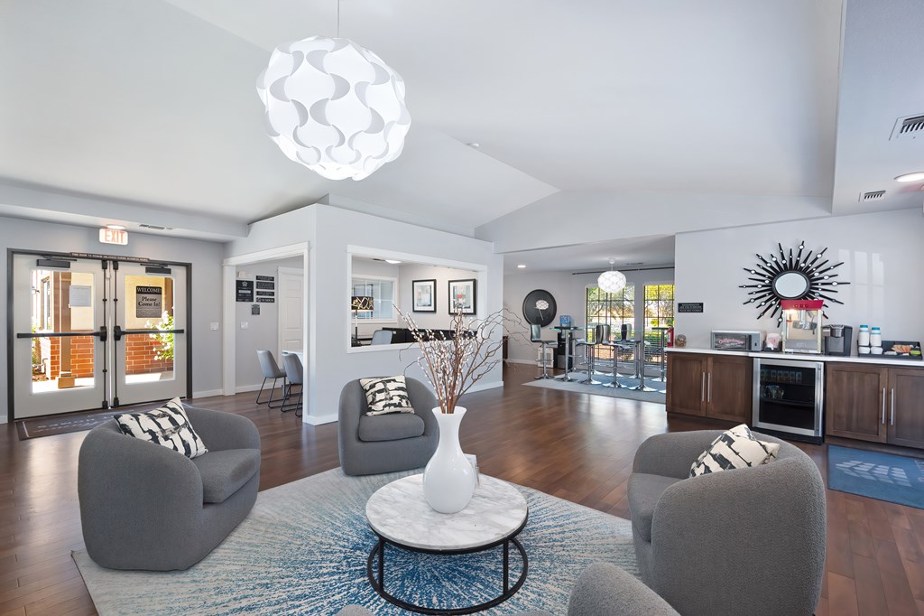 A modern living room with a grey sofa, a white coffee table, and a large chandelier.