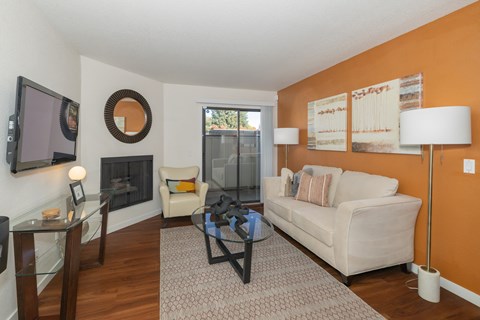 a living room with a couch and a glass coffee table and a fireplace