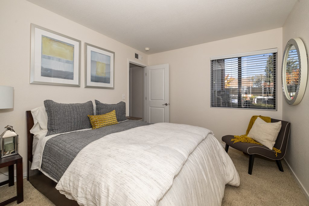 a bedroom with a large bed and a window a bedroom with a large bed and a window at Rocklin Manor Apartments, Rocklin , CA