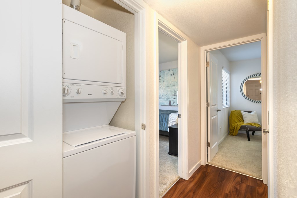 a laundry room with a washer and dryer and a door to a bedroom at Rocklin Manor  Apartments, California, 95677
