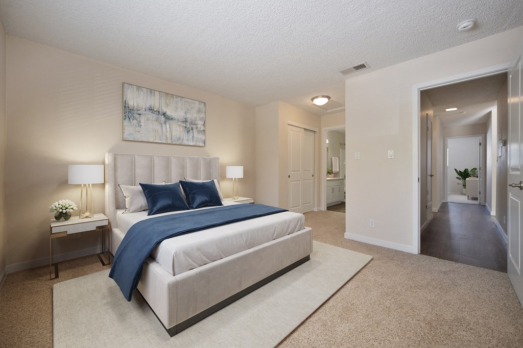 a bedroom with a white bed and blue pillows at Silverstone Apartments, Davis, California