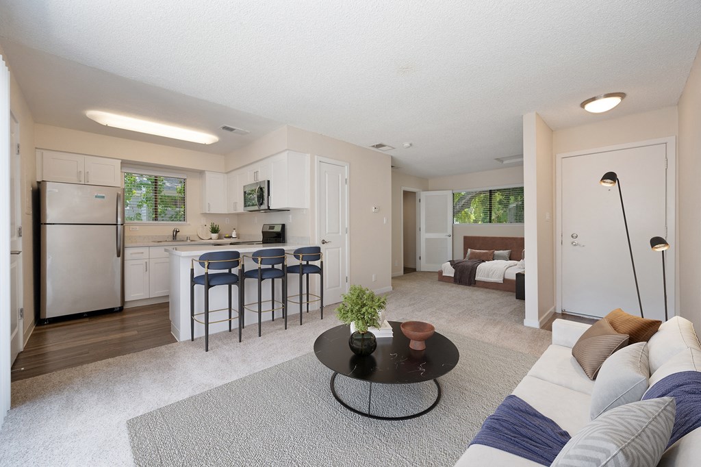 a living room with a couch and a table in front of a kitchen at Silverstone Apartments, Davis