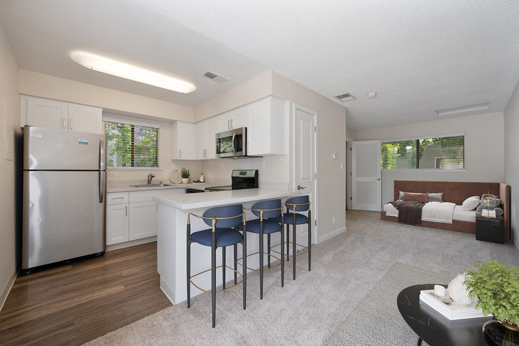 a kitchen with a bar with three stools at Silverstone Apartments, Davis, CA, 95618