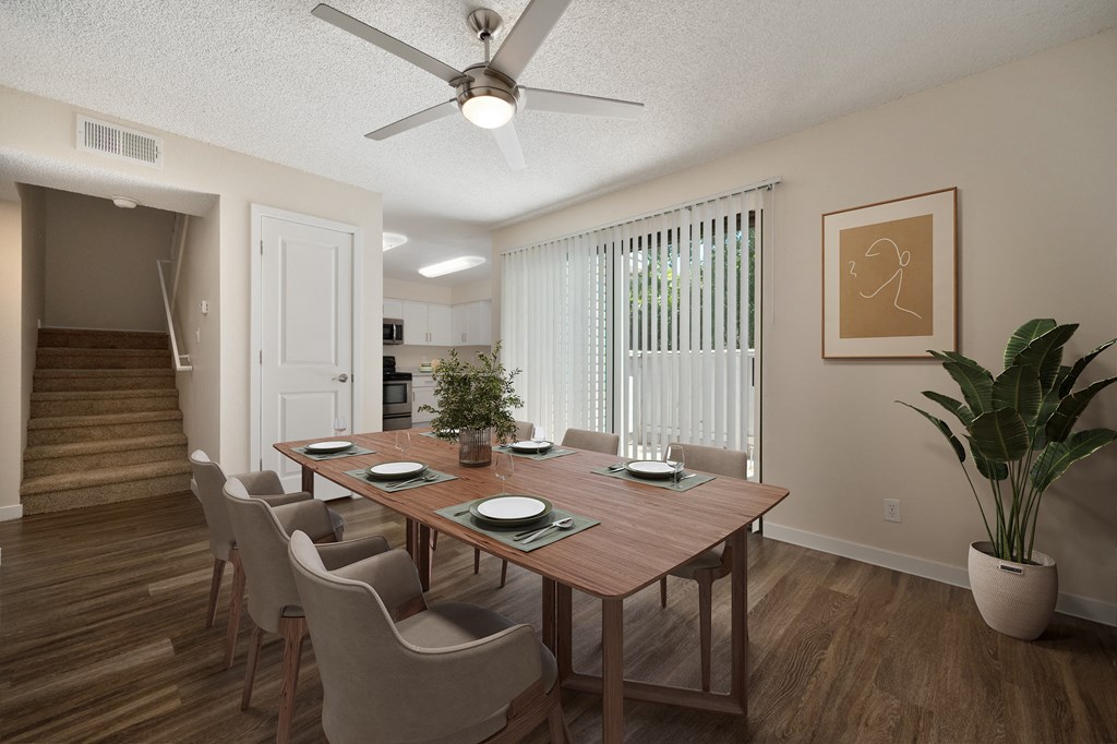 a dining room with a table and chairs and a ceiling fan in the townhome floorplan at Silverstone Apartments, Davis, California