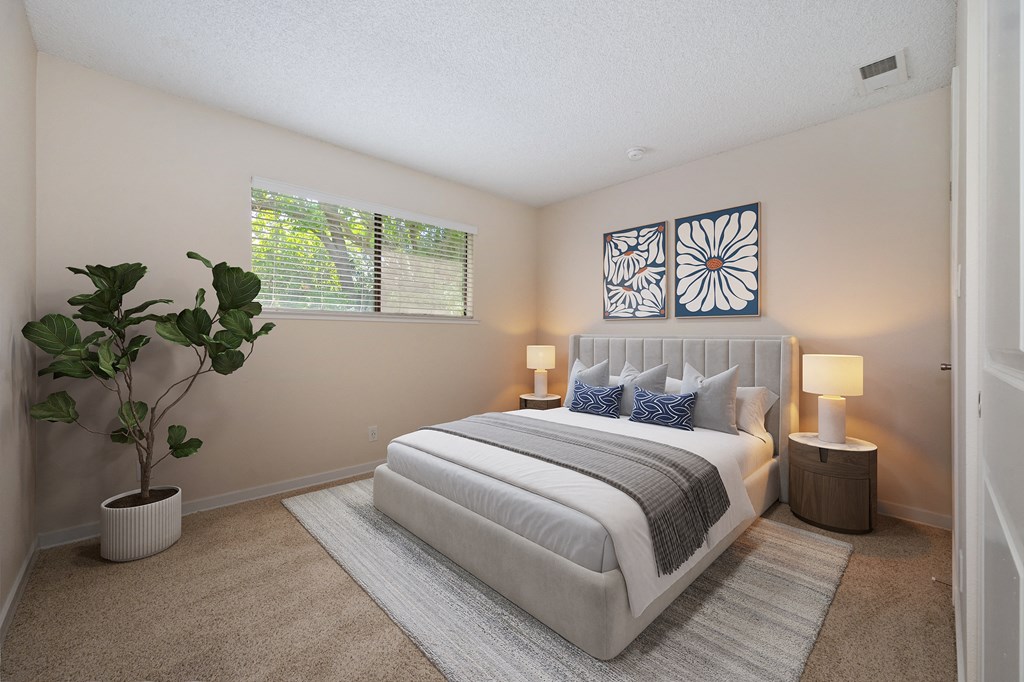 a bedroom with a white bed and a potted plant at Silverstone Apartments, Davis