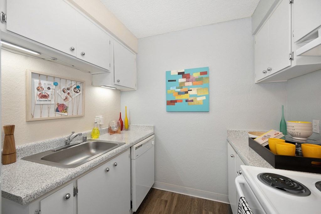 a kitchen with white cabinets and a sink and a stove