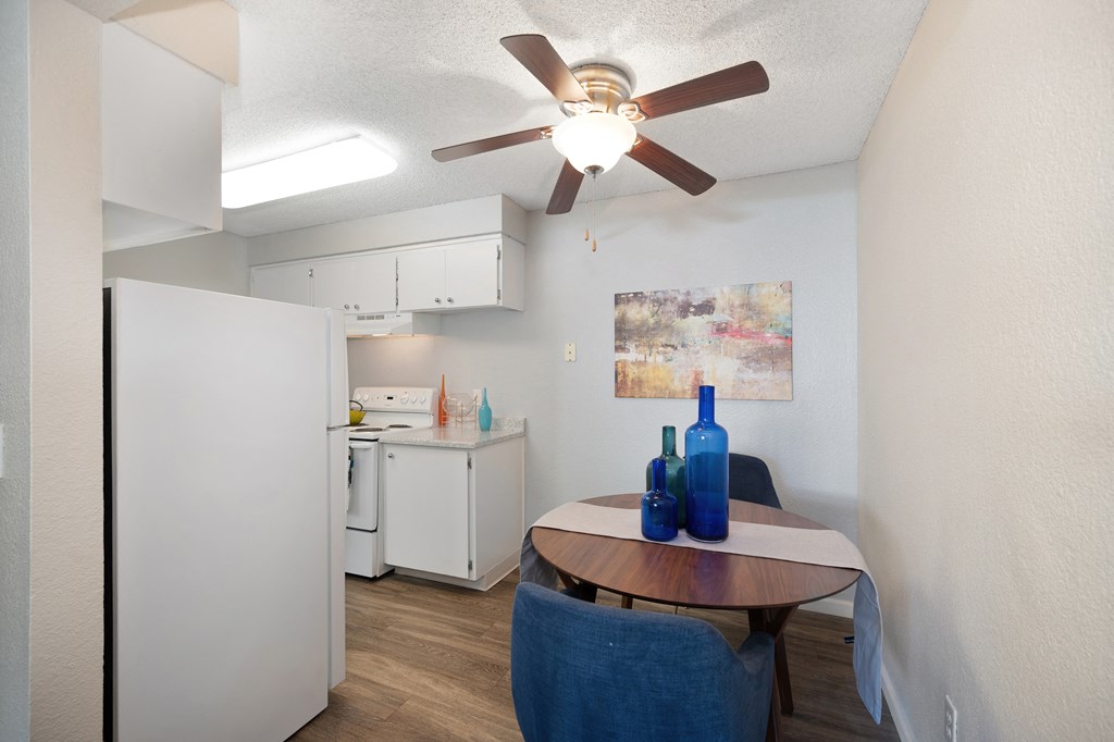 a kitchen and dining area with a table and a ceiling fan