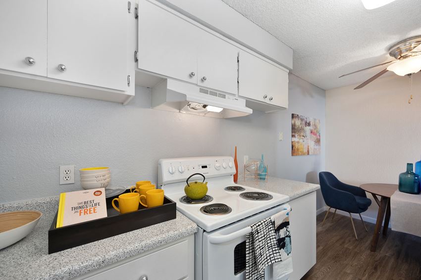Kitchen Kitchen with Stove with light colored Walls, Stove, Hardwood Inspired Floor and White Cabinets at The Renaissance Apartments, Citrus Heights