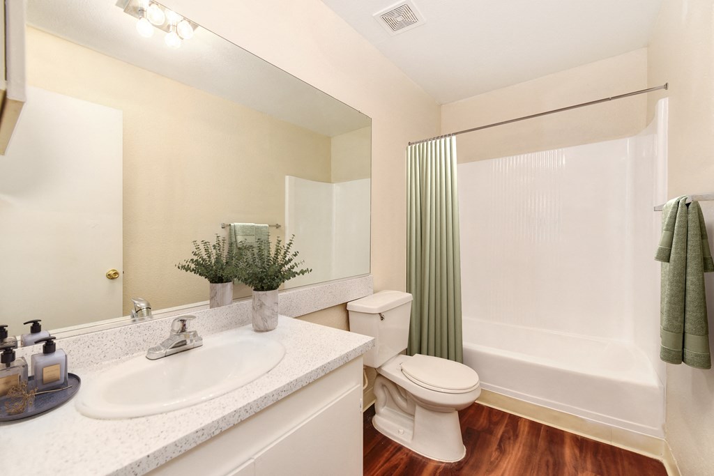 A white toilet sits next to a white sink in a bathroom.